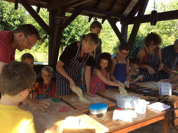 people making breads on large table